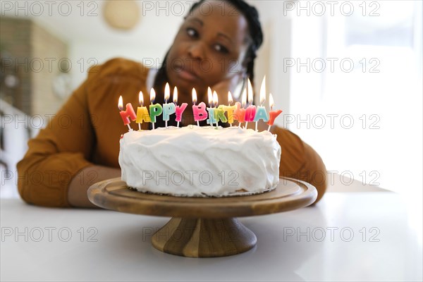 Portrait of woman behind birthday cake