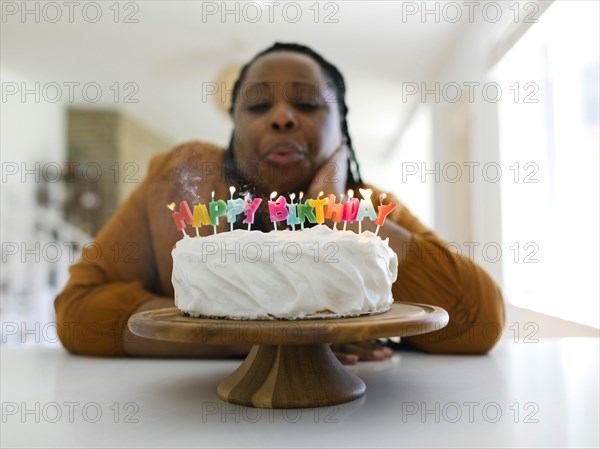 Woman blowing candles on birthday cake