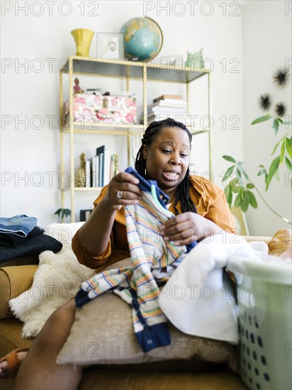 Woman folding baby clothing at home