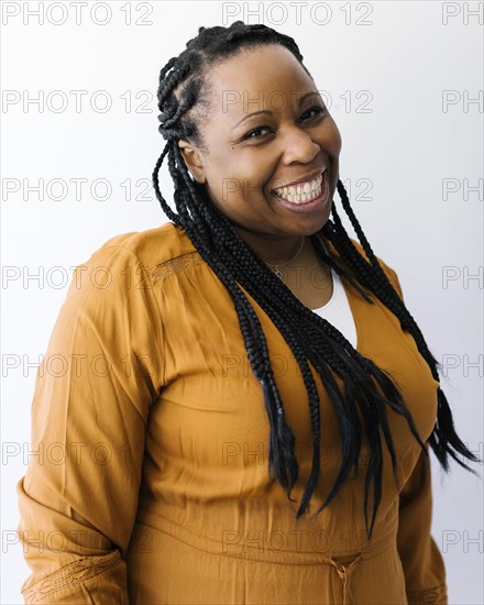 Studio portrait of braided smiling woman