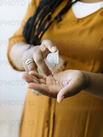 Close-up of woman cleaning hands with hand sanitizer