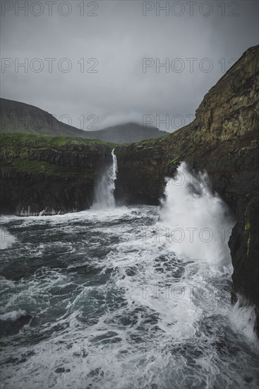 Denmark, Faroe Islands, Gasadalur village, Mulafossur Waterfall, Mulafossur Waterfall falling from cliff into ocean