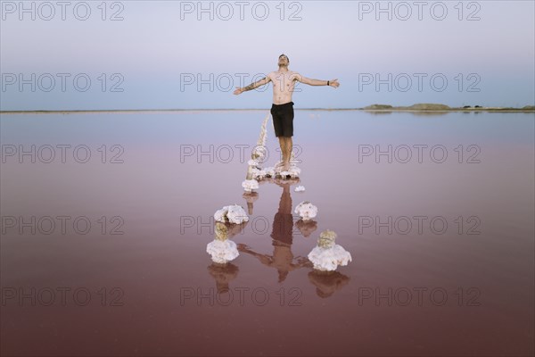 Ukraine, Crimea, Man standing on salt crystal in salt lake