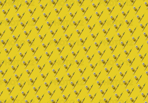 Rows of laboratory vials and syringes on yellow background