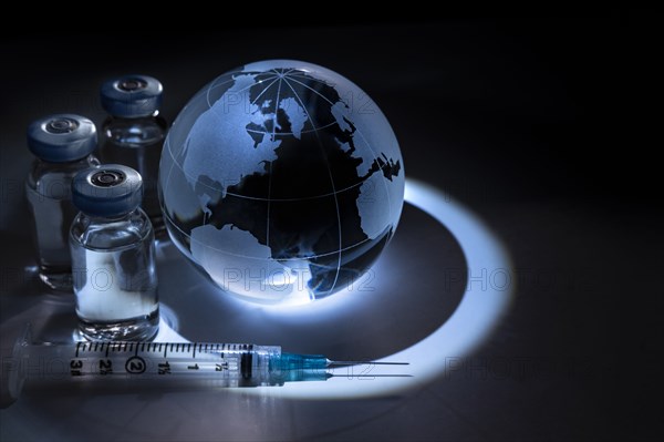 Glass globe with vials and syringe