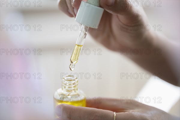 Woman's hands holding CDB oil bottle and dropper