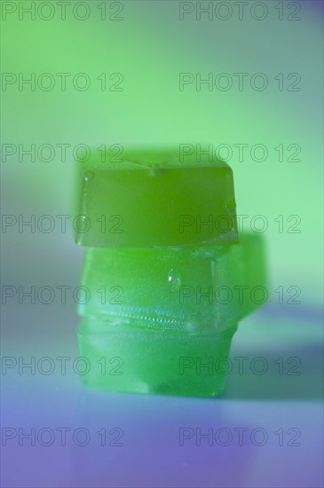 Stack of edible cannabis gummies in green light