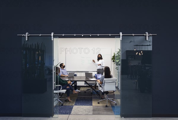 Businesspeople in face masks having meeting in office