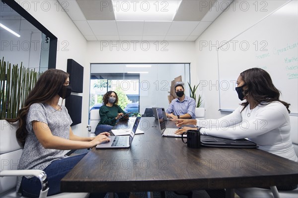 Businesspeople in face masks having meeting in office