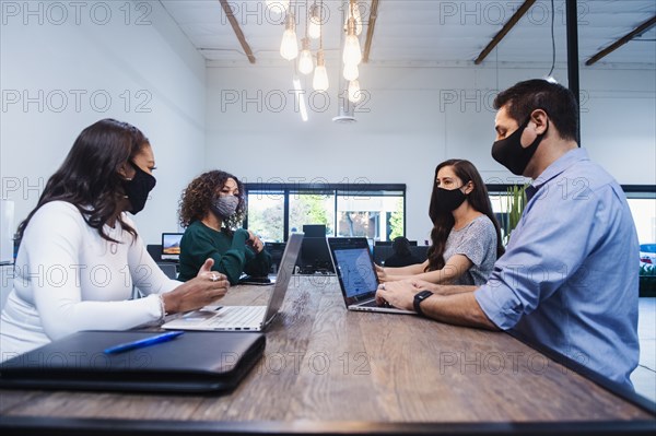 People in face masks having meeting in office