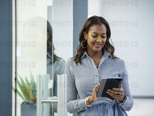 Smiling businesswoman using digital tablet in office