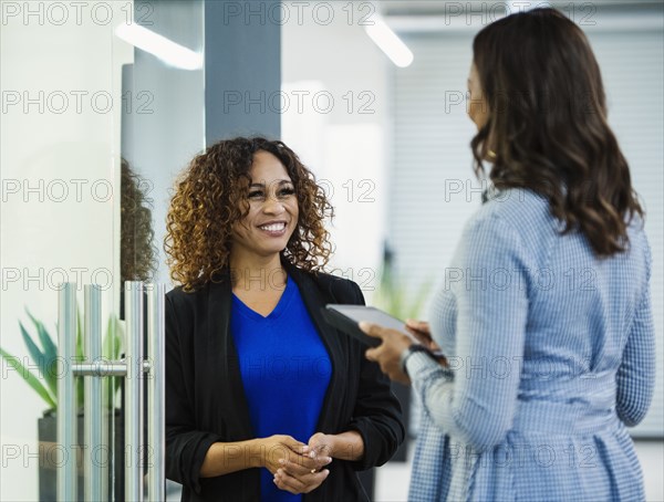 Smiling businesswomen talking in office