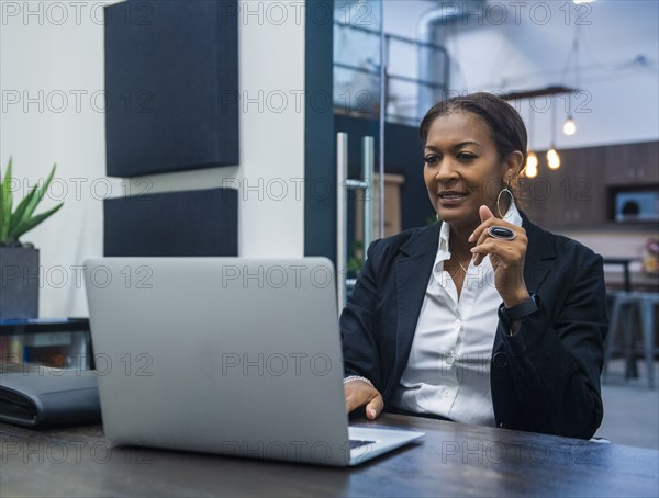 Businesswoman working on laptop at desk in office