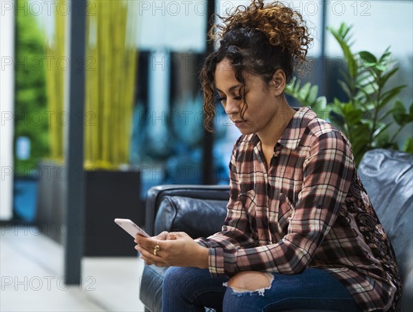 Woman sitting on sofa in office