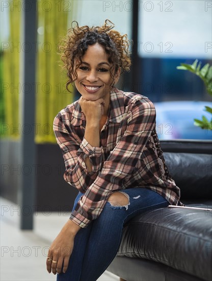 Portrait of smiling woman sitting on sofa in office