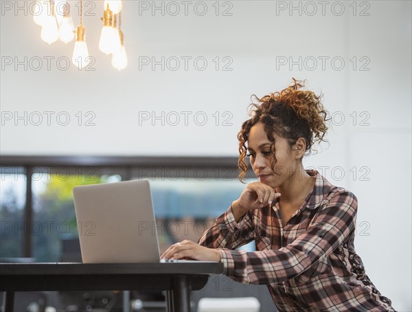 Woman sitting using laptop in office