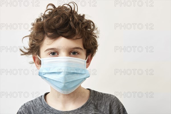 Boy (8-9) wearing protective face mask