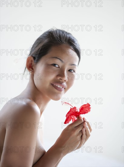 Young beautiful woman holding hibiscus flower