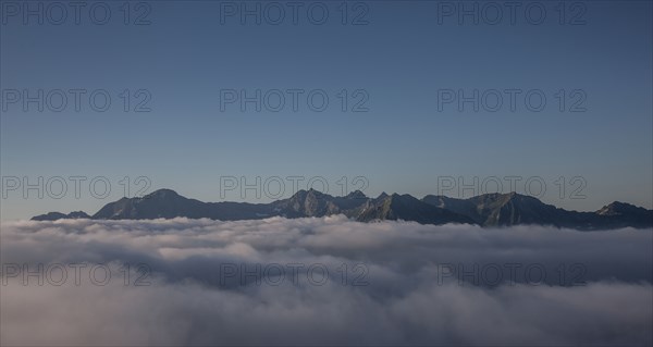 Mountain range and clouds under clear sky