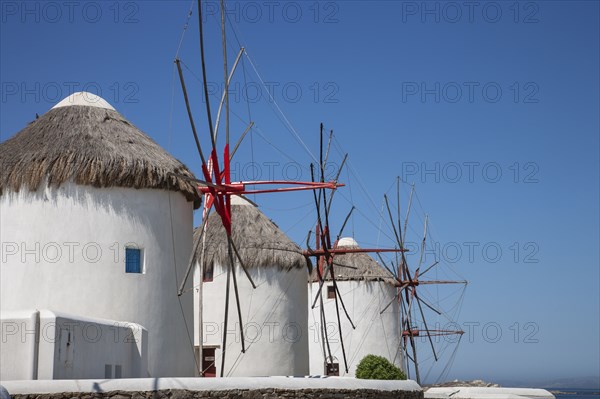 Whitewashed windmills against blue sky