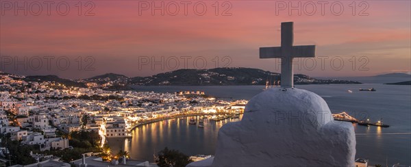 Cross on church with coastal village in background