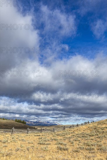 Ranch landscape with clouds and mountains in distance