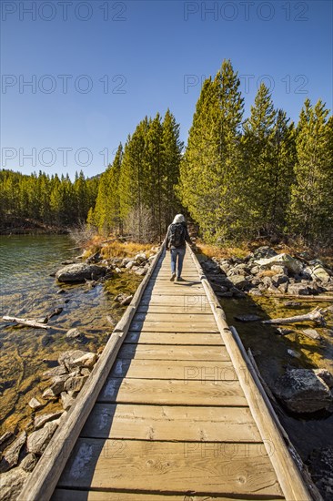 Senior woman walking on wooden path over Taggart Lake in Grand Teton National Park