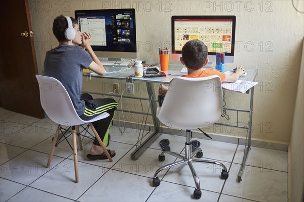 Two boys learning at desk at home during Covid-19 lockdown