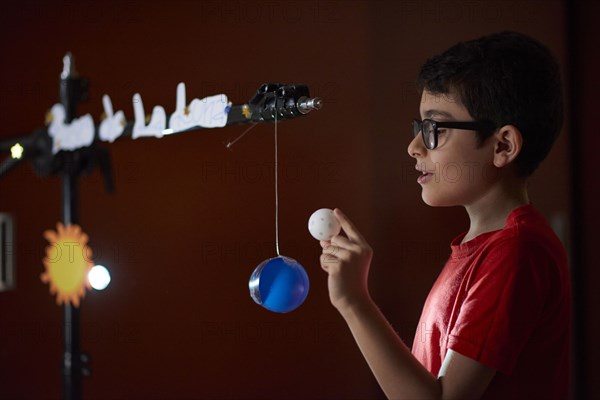 Boy (8-9) making presentation about sun phases at home school during lockdown