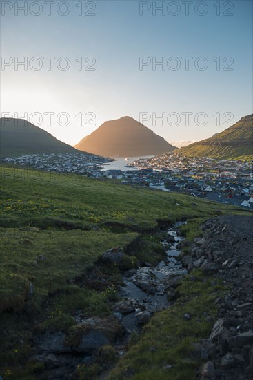 Landscape with mountains and village by sea at dawn