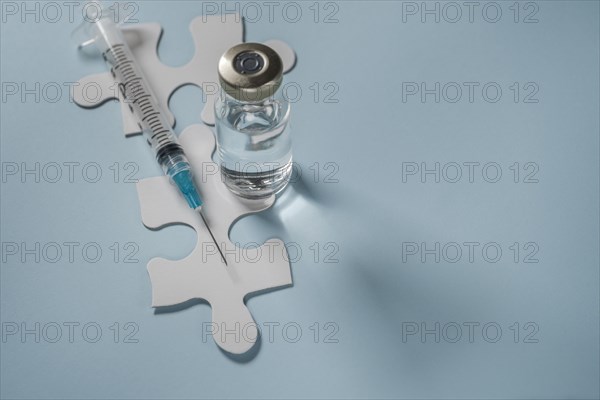 Vial of Covid-19 vaccine and syringe on jigsaw puzzles