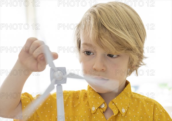 Boy (6-7) playing with wind turbine model