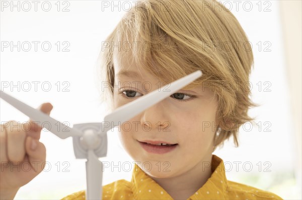 Boy (6-7) playing with wind turbine model