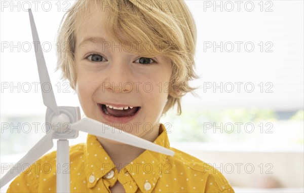 Portrait of smiling boy (6-7) with wind turbine model