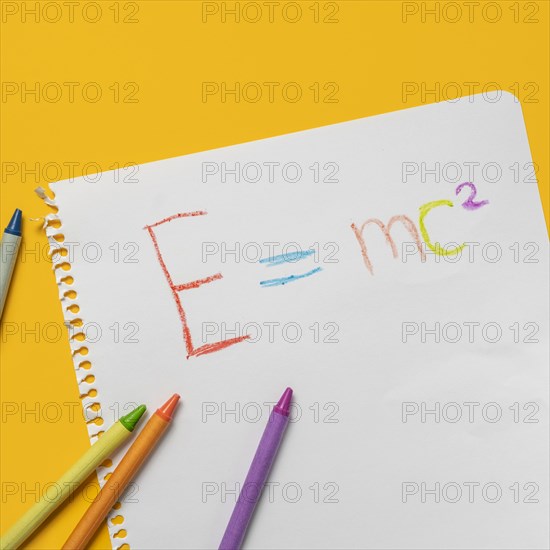 Emc2 formula on paper and colorful crayons