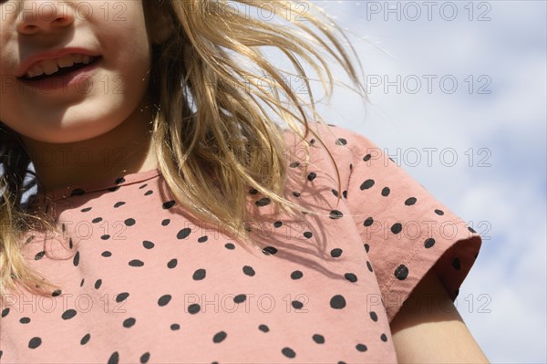 Low angle view of girl (8-9) under cloudy sky