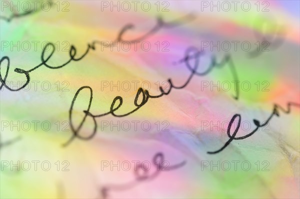 Handwriting on paper with colorful reflections