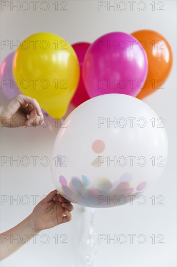 Hand holding bunch of colorful balloons