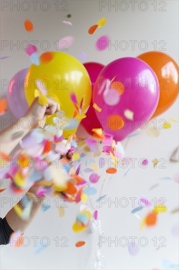 Hand holding bunch of colorful balloons