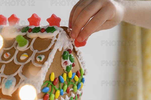 Hand decorating gingerbread house cake