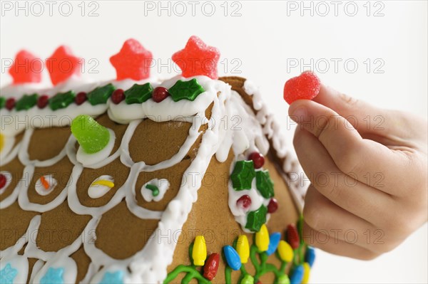 Hand decorating gingerbread house cake