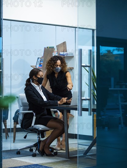 Business women wearing masks in office
