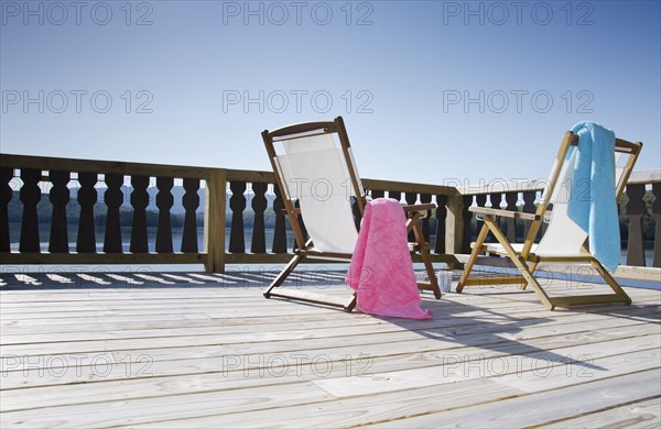 Canvas chairs on deck overlooking lake