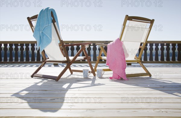 Canvas chairs on deck overlooking lake