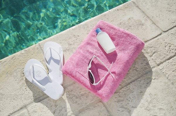 Sandals and towel at poolside