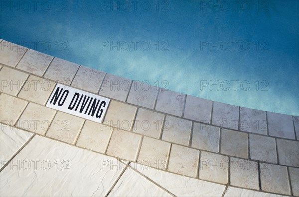 Warning sign at edge of swimming pool