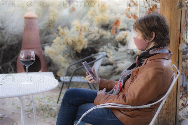 Woman wearing protective face mask sitting on bench