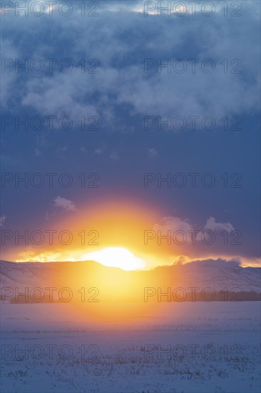 Sun setting over mountains and prairie