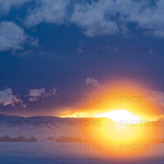 Sun setting over mountains and prairie