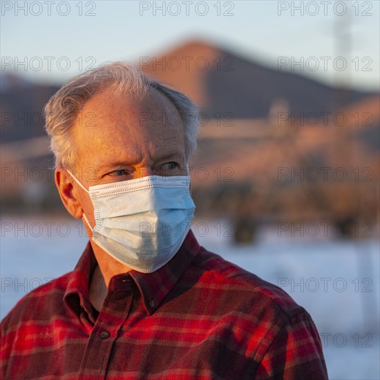 Outdoor portrait of senior man wearing COVID protective mask